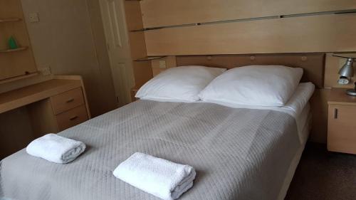 a bedroom with a bed with two towels on it at Urocza Przystan in Kiemiany