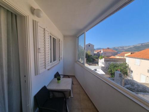 a balcony with a table and a window with a view at Guesthouse Franica in Korčula