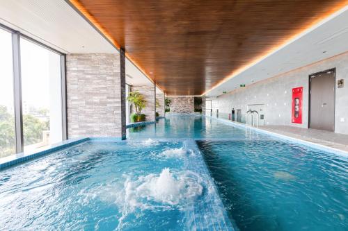 uma piscina interior com água azul num edifício em Five Star Westlake 1st-4th Floors Hotel & Serviced Apartment em Hanói