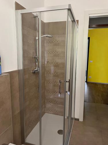 W łazience znajduje się prysznic ze szklanymi drzwiami. w obiekcie Appartamento Mela ad Alba, cuore delle Langhe w Albie