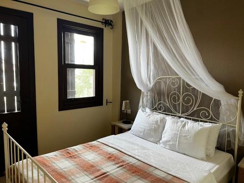 a bedroom with a bed with a canopy and a window at Han Boutique Hotel in Sarigerme