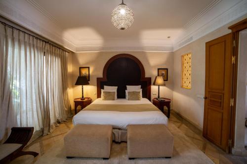 a bedroom with a large bed and a chandelier at Le Riad Villa Blanche in Agadir