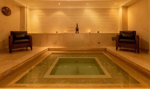 a large room with two chairs and a swimming pool at Le Riad Villa Blanche in Agadir