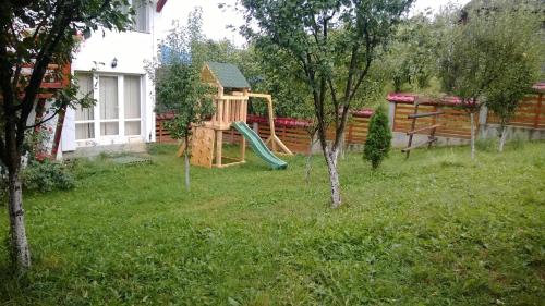 a backyard with a playground with a slide at Pensiunea Valcinet in Borşa