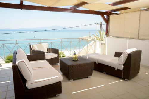 a balcony with chairs and a view of the ocean at AGALI 2 Superior Mezonet front of the sea in Akrogiali
