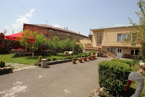 a yard with a house and a patio with plants at Mardoyan's Guest house in Gavarr