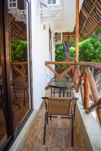 a table and chairs on the porch of a house at Sheratton Beach Villagio in Mombasa