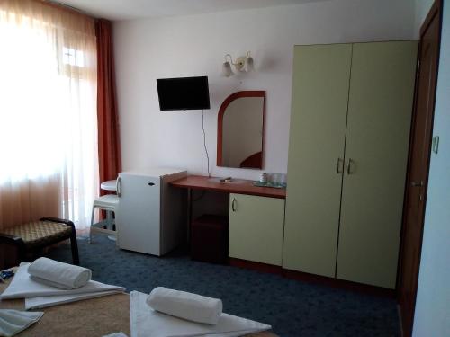 a hotel room with a vanity and a mirror at Family hotel Dramchev in Nesebar