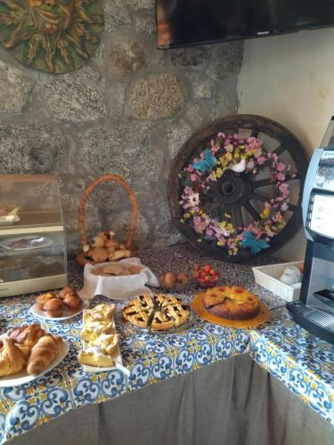 einen Tisch mit verschiedenen Arten von Gebäck und Brot in der Unterkunft agriturismo heaven in Capo Vaticano