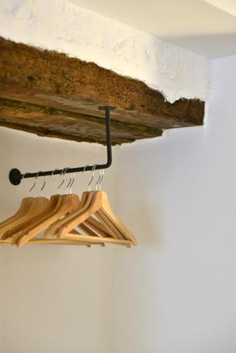 a bunch of wooden hangers hanging from a ceiling at Hydra Icons in Hydra