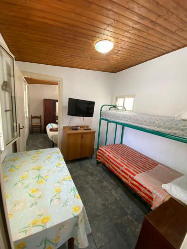 a bedroom with two bunk beds and a television at La casetta in Bova Marina