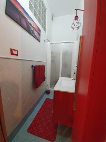 a red bathroom with a white sink and a red rug at One Love Ortigia in Syracuse