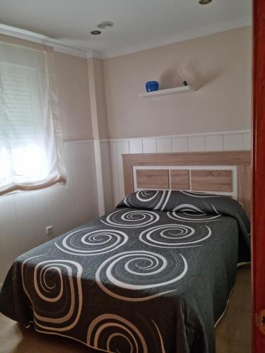1 dormitorio con 1 cama con manta negra y marrón en Peñuelas Apartment en Lucena