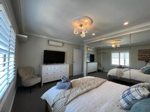 a bedroom with two beds and a flat screen tv at STUNNING! 'New York Style' Roof Top 2 Car Apartment in Perth