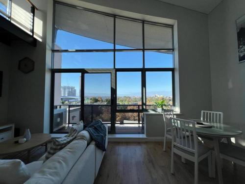a living room with a couch and a table at STUNNING! 'New York Style' Roof Top 2 Car Apartment in Perth