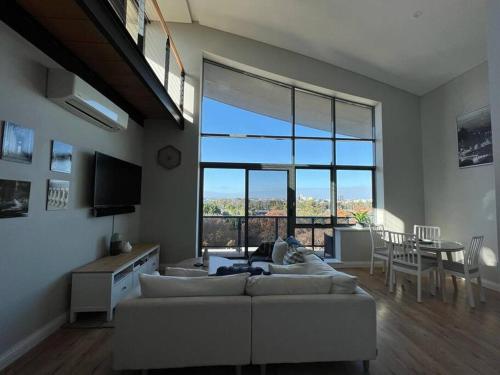 a living room with a white couch and a large window at STUNNING! 'New York Style' Roof Top 2 Car Apartment in Perth