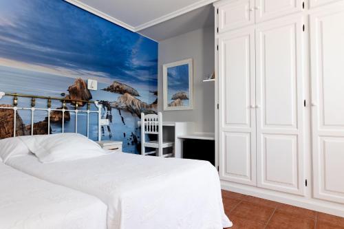 a bedroom with a white bed and a blue wall at La Solana Montañesa in Comillas