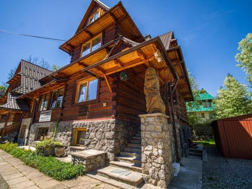 a large wooden house with stairs in front of it at Apartamenty u drwala in Zakopane