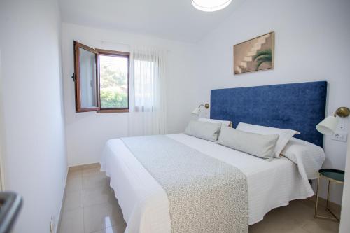 a bedroom with a white bed with a blue headboard at Bungalows Deluxe Las Vegas Golf in Maspalomas