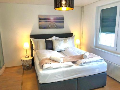 een slaapkamer met een groot bed en handdoeken bij Grubenmann Appartements - Sankt Gallen City in St. Gallen