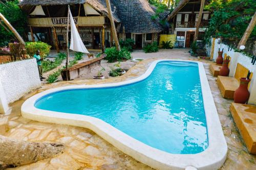 a swimming pool in a yard with a house at Utupoa in Matemwe