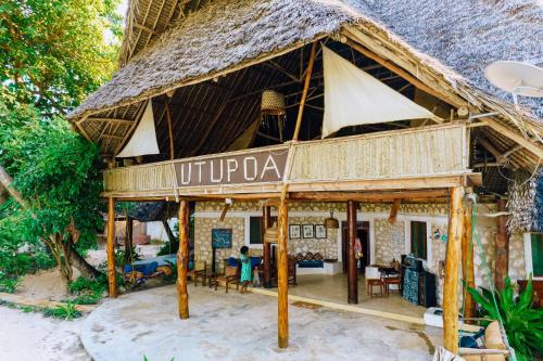 a hut with a sign that says utopia at Utupoa in Matemwe