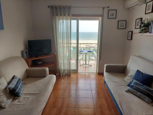 a living room with a couch and a view of the ocean at À da Mamé - Monte Gordo in Monte Gordo