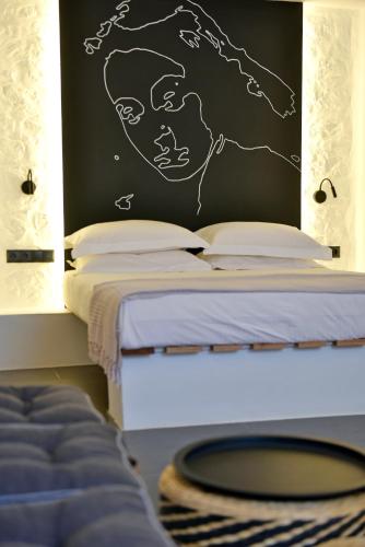 a bedroom with a bed with a chalkboard on the wall at Hydra Icons in Hydra