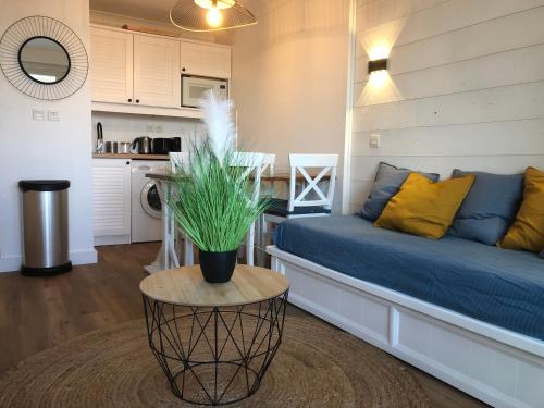 un salon avec un canapé bleu et une table dans l'établissement Sympathique appartement en bord d'océan, à Lacanau