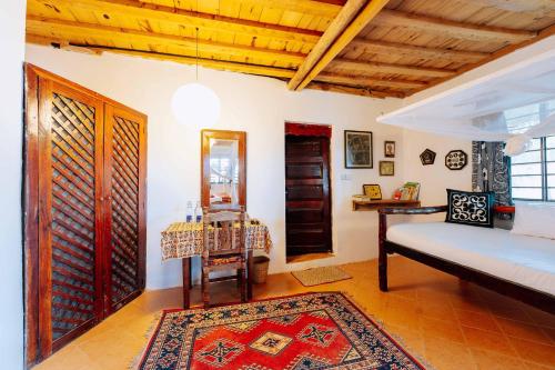 a bedroom with a bed and a table and a mirror at Utupoa in Matemwe