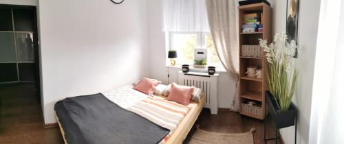 a small bedroom with a bed and a window at Apartament Woda Morska in Ustka