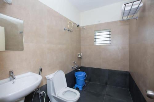 Un baño con un inodoro blanco y un lavabo. en HOTEL VIJAYA LAKSHMI RESIDENCY - YESHWANTHPUR, en Bangalore