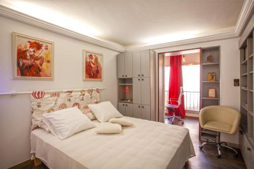 a bedroom with a bed and a chair and a window at Lucamare - Casa Rossa in LʼÎle-Rousse
