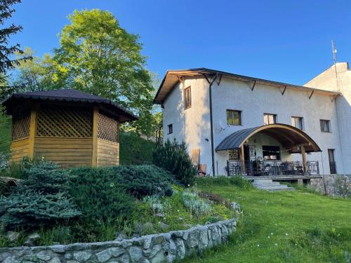 a building with a gazebo next to a yard at Hotel Brainy in Krásno nad Kysucou