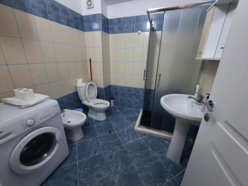 uma casa de banho com um WC, um lavatório e uma máquina de lavar roupa em Antea Apartment 3 em Vlorë