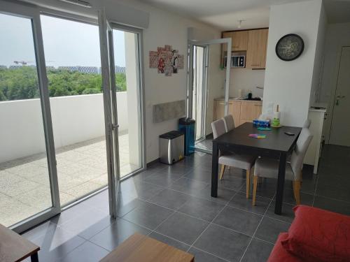 une cuisine et une salle à manger avec une table avec vue dans l'établissement Appartement résidence récente, à Bayonne