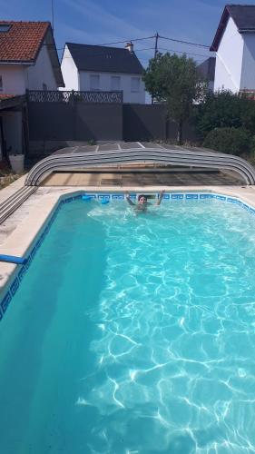 une piscine avec de l'eau bleue dans une cour dans l'établissement Mon rêve, au Pouliguen