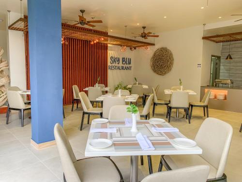 a dining room with white tables and chairs at Sky Beach Maldives - Dhiffushi in Dhiffushi