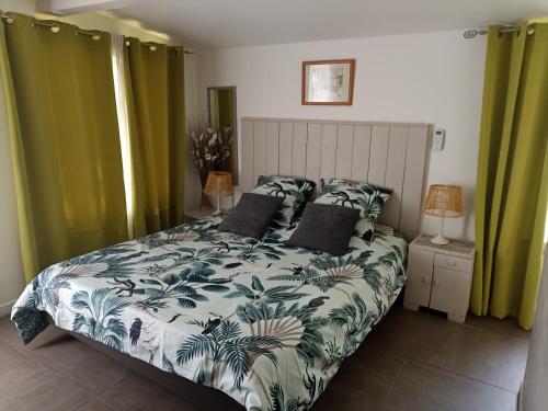 Schlafzimmer mit einem großen Bett und grünen Vorhängen in der Unterkunft Chambre d'Hôte - Mas Le Barret in Arles