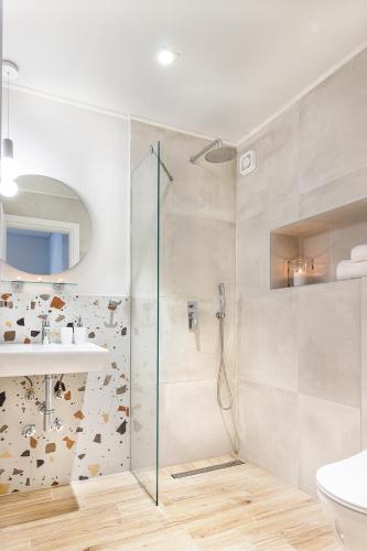 a bathroom with a shower and a toilet and a sink at 9 Luxury Rooms in Sarti