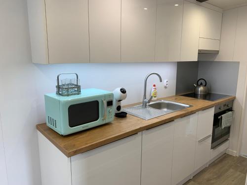 a kitchen with a microwave and a sink at Cyprianus village in Poprad