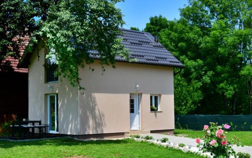 a small house in a yard with a tree at Apartments Green Linden in Rakovica