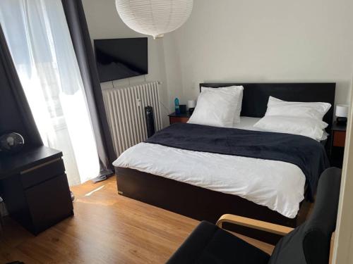 a bedroom with a bed with a black and white comforter at Trier City Center Apartments & Stadthaus, Zentrum in Trier