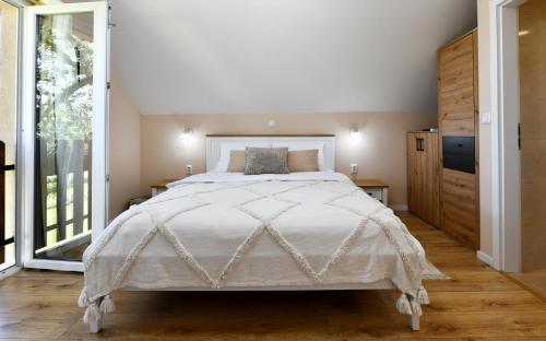 a bedroom with a large bed and a large window at Apartments Green Linden in Rakovica