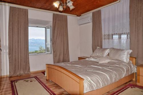 een slaapkamer met een bed en een groot raam bij Skadar Lake House in Bar