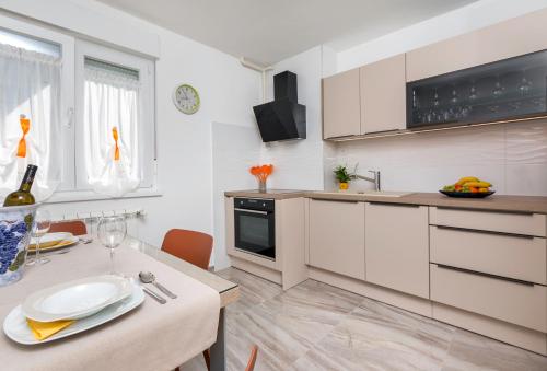una cocina con armarios blancos y una mesa con un plato. en Apartment Vivid, en Pula