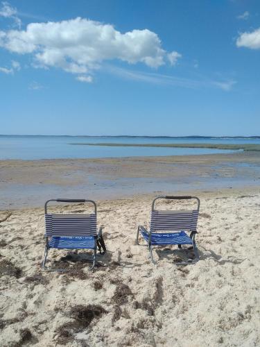 - deux chaises de plage assises sur le sable sur la plage dans l'établissement Studio Andernos vue Bassin port ostréicole charmant et lumineux avec piscine et balcon !, à Andernos-les-Bains