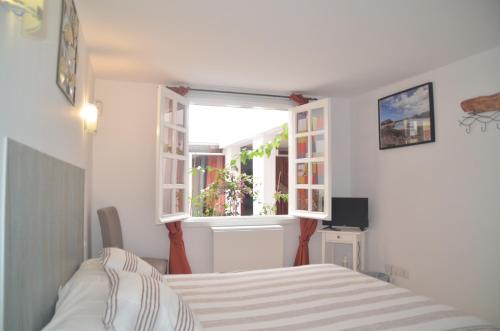 a bedroom with a bed and a window at HOTELITO RURAL GA7COLORES only adult in Montaña Blanca