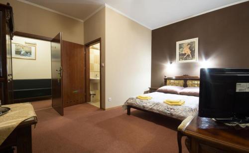 a bedroom with a bed with yellow towels on it at Gościniec & SPA Darłowo in Darłowo