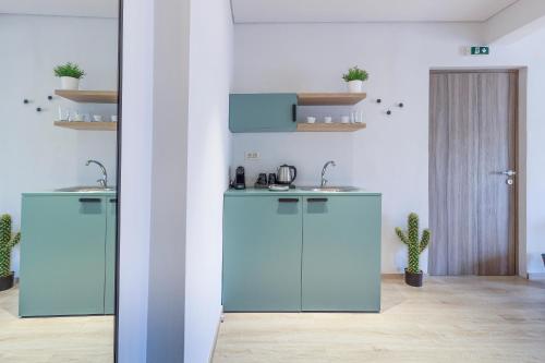 una cucina con armadi blu e lavandino di 9 Luxury Rooms a Sárti